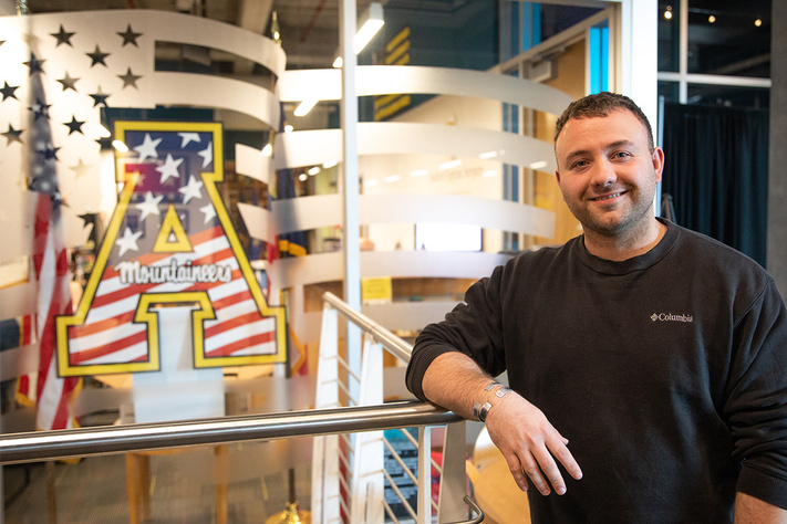 A student standing in front of the Student Veterans Services Resource Center