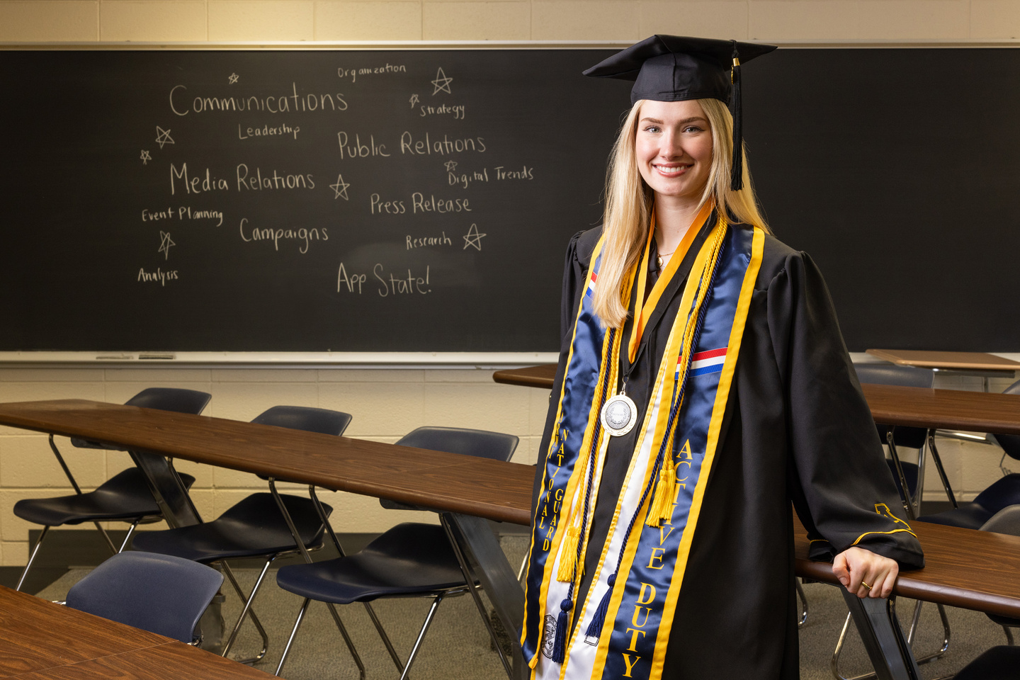 Veteran Grad posing in a classroom